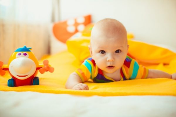 baby-lying-on-a-yellow-bed_1304-252
