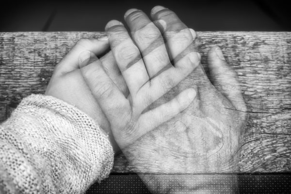 Einfühlsame Aufnahme von zwei Händen zum Thema Trennung, Tod und Vermissen